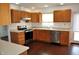 This kitchen has wood cabinets and stainless steel appliances and a wood floor at 3513 Berkdale Dr, Columbus, IN 47203