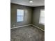 This bedroom features neutral-colored walls and floors, and updated windows with blinds at 3521 N Rural St, Indianapolis, IN 46218