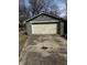 A detached, single-car garage with a large overhead door is located at the end of a long concrete driveway at 3521 N Rural St, Indianapolis, IN 46218