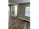 Living room with a gray wall, wood floor, and white trim windows with blinds at 3521 N Rural St, Indianapolis, IN 46218