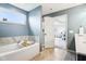 A well-lit bathroom offers a modern tub, tiled floor, and bright window at 3645 Conifer Dr, Zionsville, IN 46077