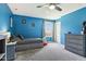 Well-lit bedroom features blue walls, carpet, ceiling fan, daybed with storage, and dresser at 3645 Conifer Dr, Zionsville, IN 46077