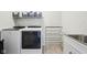 Bright laundry room with white washer and dryer, storage shelf, drying rack, and utility sink at 3645 Conifer Dr, Zionsville, IN 46077