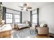 Cozy bedroom with two windows, ceiling fan, dresser, comfy chair, carpet, and wood floors at 3652 N Delaware St, Indianapolis, IN 46205