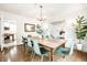 Bright dining room with an elegant chandelier, wooden table with green chairs, and open access to other rooms at 3652 N Delaware St, Indianapolis, IN 46205
