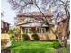 Charming brick home featuring a covered front porch, well-maintained lawn, and a blossoming tree at 3652 N Delaware St, Indianapolis, IN 46205