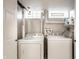 Bright laundry room featuring white appliances and functional shelving for organized storage at 3652 N Delaware St, Indianapolis, IN 46205