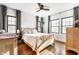 Bright bedroom with a wooden bed frame, hardwood floors, large windows, and dark curtains at 3652 N Delaware St, Indianapolis, IN 46205