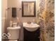 Compact bathroom with a modern vanity, framed mirror, and a vibrant floral shower curtain at 428 E Trevor St, Brownsburg, IN 46112