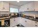 Well-lit kitchen with white cabinetry, dark countertops, and stainless steel appliances at 428 E Trevor St, Brownsburg, IN 46112