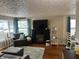 Bright living room with a decorative fireplace, large windows, and hardwood floors at 428 E Trevor St, Brownsburg, IN 46112