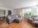Cozy living room with wood floors, neutral sofa, and natural light from large windows at 428 E Trevor St, Brownsburg, IN 46112