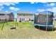 Fenced backyard with trampoline, swing set, and expansive lawn providing a safe play area at 4345 Maize Ln, Whitestown, IN 46075