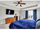 Stylish main bedroom featuring a blue bedspread, a ceiling fan, and ample storage options at 4345 Maize Ln, Whitestown, IN 46075