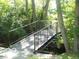 A small bridge with metal railings passes through a densely wooded area at 4814 Lynton Ct, Indianapolis, IN 46254