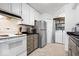 Bright kitchen features white cabinets, stainless steel refrigerator, and convenient in-unit washer and dryer at 4814 Lynton Ct, Indianapolis, IN 46254