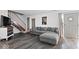 Modern living room with gray sofa, wood floors, staircase, and a stylish front door at 4814 Lynton Ct, Indianapolis, IN 46254
