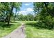 A winding walking path passes through a grassy field surrounded by mature trees at 4814 Lynton Ct, Indianapolis, IN 46254