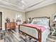 Comfortable bedroom boasts a large bed, wood-look floors, and a view of the en suite bathroom and kitchen at 4993 Silverbell Dr, Plainfield, IN 46168