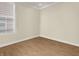 A small, empty bedroom with wood-look floors and a large window at 4993 Silverbell Dr, Plainfield, IN 46168