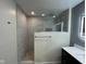 Bathroom showing a marble tiled shower, dark vanity with quartz counter, and LED mirror at 5105 Manning Rd, Indianapolis, IN 46228