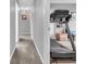 Hallway featuring gray walls, neutral carpet, and a view into a workout area with a treadmill at 5524 Cherry Blossom Ct, Indianapolis, IN 46237