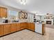 Open-concept kitchen with wood cabinets and adjacent view into the living room with a fireplace at 5524 Cherry Blossom Ct, Indianapolis, IN 46237