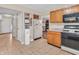 Functional kitchen layout with tiled floor, wood cabinetry, and access to other rooms at 5524 Cherry Blossom Ct, Indianapolis, IN 46237
