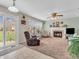 Cozy living room featuring a fireplace, plush carpet, and a sliding door leading to the yard at 5524 Cherry Blossom Ct, Indianapolis, IN 46237