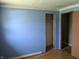 Bedroom with hardwood floors, blue painted walls and a closet ready to be customized at 5961 N 200 W, Columbus, IN 47201