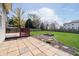 Spacious backyard with a deck, patio, green grass, and wooden fence at 6134 Chadsworth Way, Lawrence, IN 46236