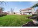 Large, well-manicured backyard with a wooden fence, raised garden beds, and patio at 6134 Chadsworth Way, Lawrence, IN 46236