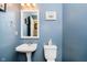 Cozy half-bathroom featuring stylish blue paint, a pedestal sink, and classic fixtures at 6134 Chadsworth Way, Lawrence, IN 46236