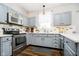 Well-lit kitchen featuring stainless steel appliances, gray cabinetry, and updated countertops at 6134 Chadsworth Way, Lawrence, IN 46236