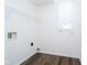 Bright laundry room with wood-look flooring, white walls and practical shelving with window for natural light at 6134 Chadsworth Way, Lawrence, IN 46236
