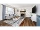 Comfortable living room featuring a stone fireplace, a large window, and contemporary decor at 6134 Chadsworth Way, Lawrence, IN 46236