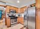 Bright kitchen featuring stainless steel appliances, wood cabinets, and tile flooring at 6347 St Joe Dr, Indianapolis, IN 46217