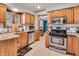 Well-lit kitchen with wood cabinets, stainless steel appliances, and granite countertops at 6347 St Joe Dr, Indianapolis, IN 46217