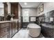 Elegant bathroom with a freestanding tub, dark wood cabinets, and stylish wall tiles at 650 Forest Blvd, Indianapolis, IN 46240