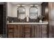 Bathroom featuring dark wood vanity with double sinks, marble countertop, and decorative mirrors at 650 Forest Blvd, Indianapolis, IN 46240