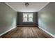 Cozy bedroom with hardwood floors, soft green walls, and a large window for natural light at 650 Forest Blvd, Indianapolis, IN 46240