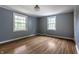 Light-filled bedroom with hardwood floors, two large windows, and neutral gray paint at 650 Forest Blvd, Indianapolis, IN 46240