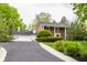 Inviting brick home featuring an attached garage, long driveway, and lush greenery at 650 Forest Blvd, Indianapolis, IN 46240