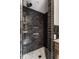 Modern bathroom shower featuring dark tile walls, a built-in niche, and a shower head with mounted controls at 650 Forest Blvd, Indianapolis, IN 46240