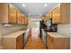 Efficient kitchen featuring stainless steel appliances, wood cabinets, and a view to the outdoor balcony at 652 Blossom Dr, Avon, IN 46123
