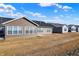 View of multiple homes with black roofs and brown or grey siding, and grassy backyards at 7111 Lillian Pl, Cumberland, IN 46229