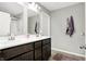 Bathroom with double sink vanity, large mirror, and shower behind glass door at 7111 Lillian Pl, Cumberland, IN 46229