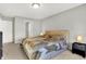 Well-lit bedroom with neutral walls and carpet, complemented by lamps and earth-tone bedding at 7111 Lillian Pl, Cumberland, IN 46229