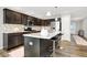 Modern kitchen with a central island, stainless steel appliances, and dark brown cabinetry at 7111 Lillian Pl, Cumberland, IN 46229