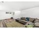 Basement living room with a large sectional sofa, exercise area, and green geometric rug at 7138 Avalon Trail Ct, Indianapolis, IN 46250